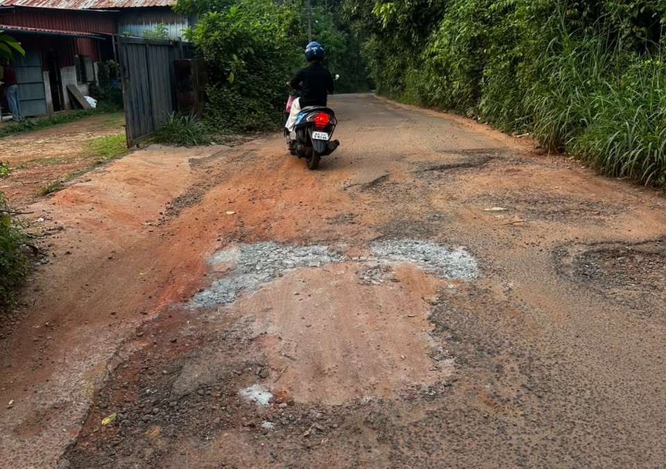 A scooter riding over the broken, untarred Melmuri road